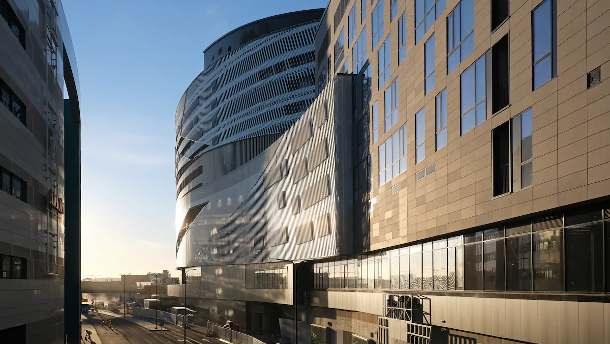 Nokia Arenan lasijulkisivu Tampereen ratapihan yllä iltahämärässä