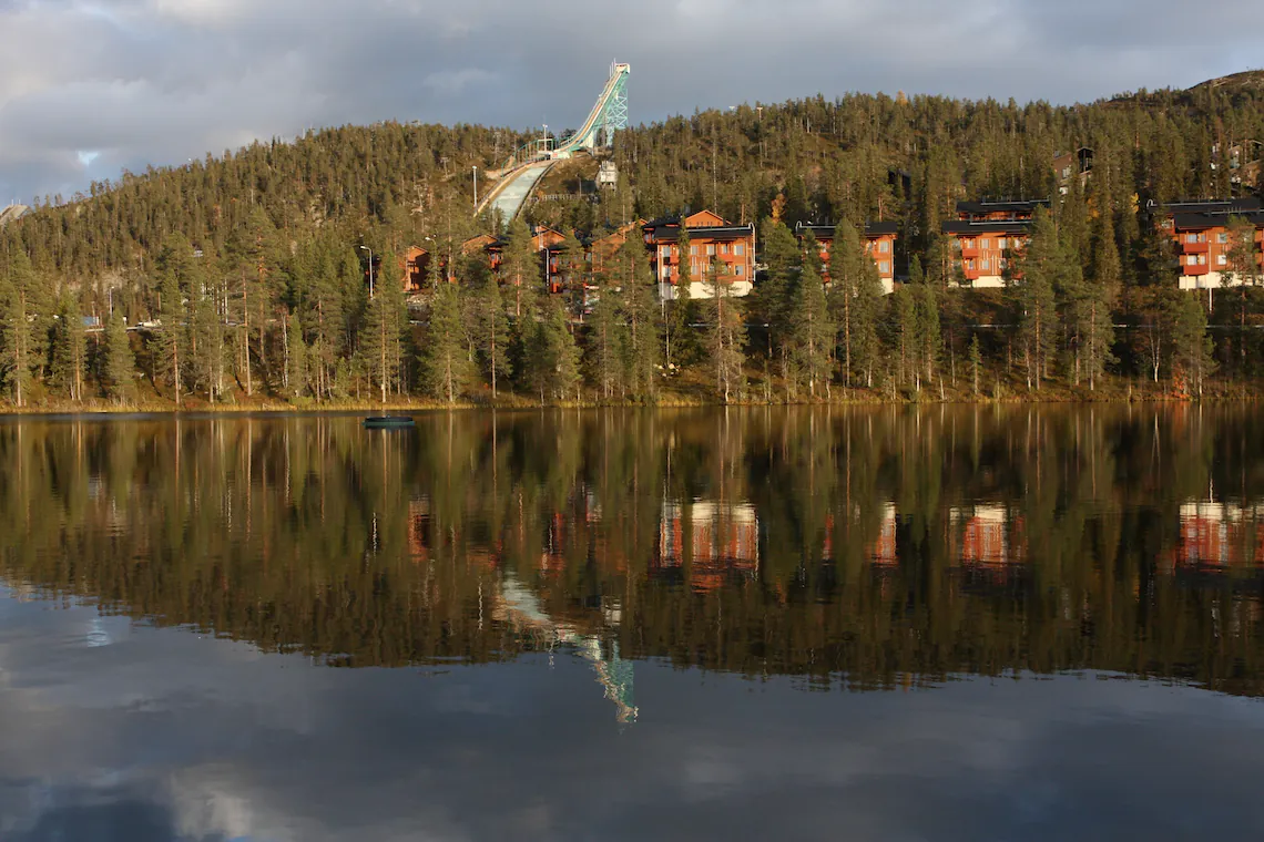Rukan rinne ja hyppyrimäki järven takaa loppusyksyn valossa